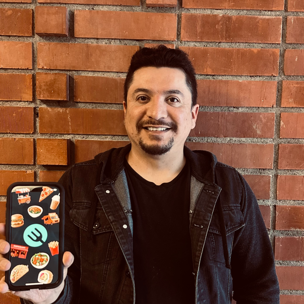 Luis Calvillo a tech founder holding an iPhone with the WhattaEat app.